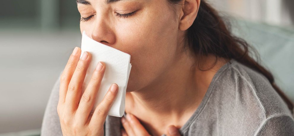 Mujer joven respira profundamente al aire libre en primavera, luz suave, bienestar y confort respiratorio